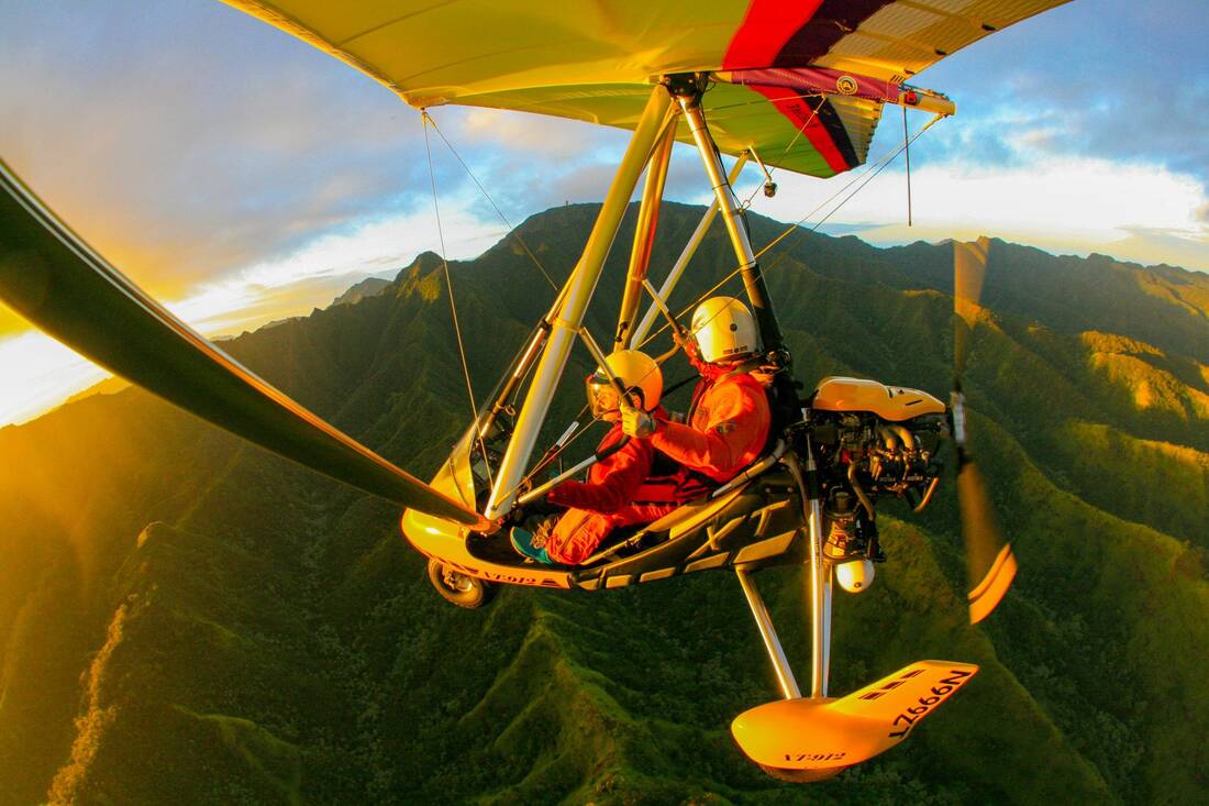 The trike in golden light, the sun low behind a mountain ridge