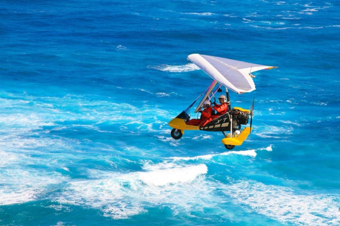 Two aboard the trike, low over bright turquoise water